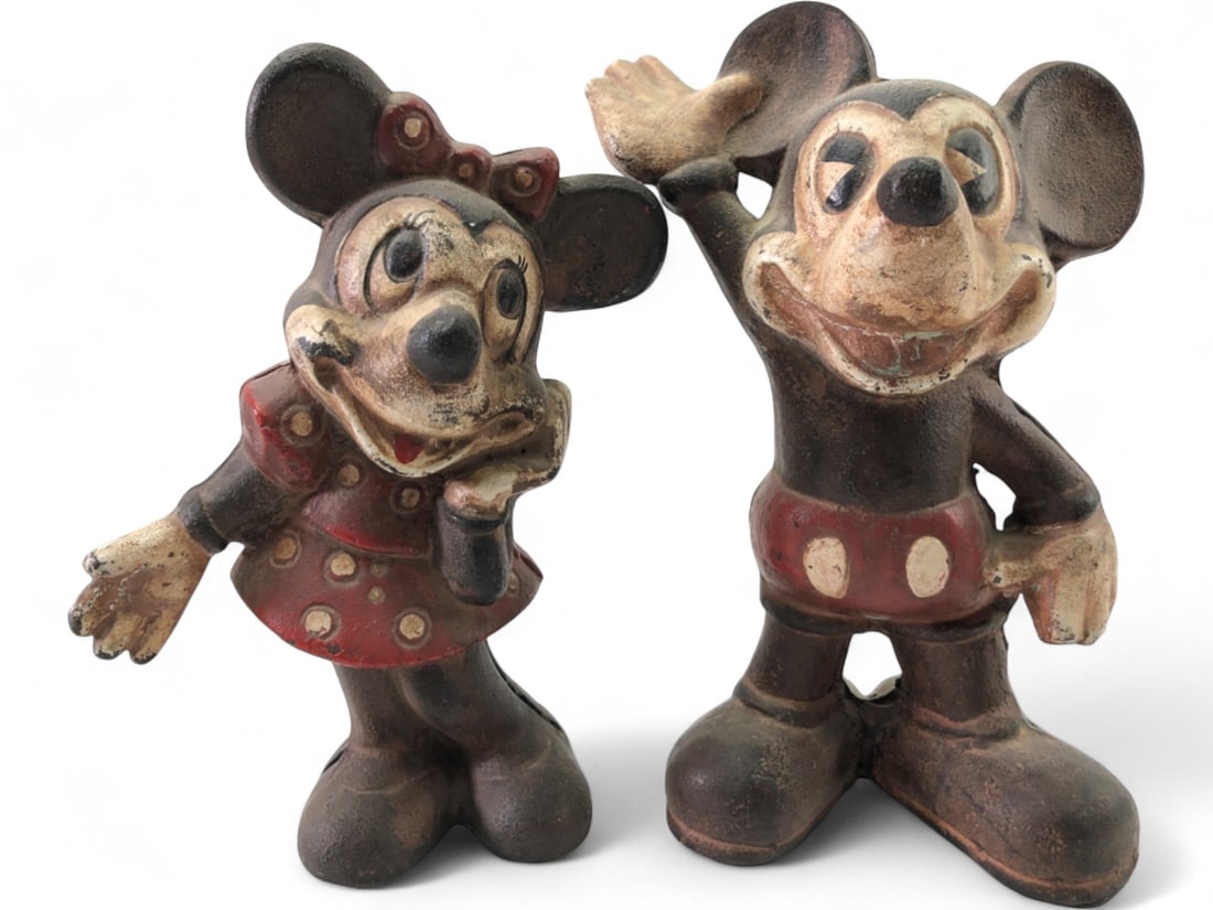 Cast Iron Mickey & Minnie Mouse Coin Banks: Pr. of vintage cast iron Mickey & Minnie Mouse coin banks. Features original painted details with wear consistent with age. Mickey measures 9" tall, Minnie measures 8.5" tall. Unmarked.