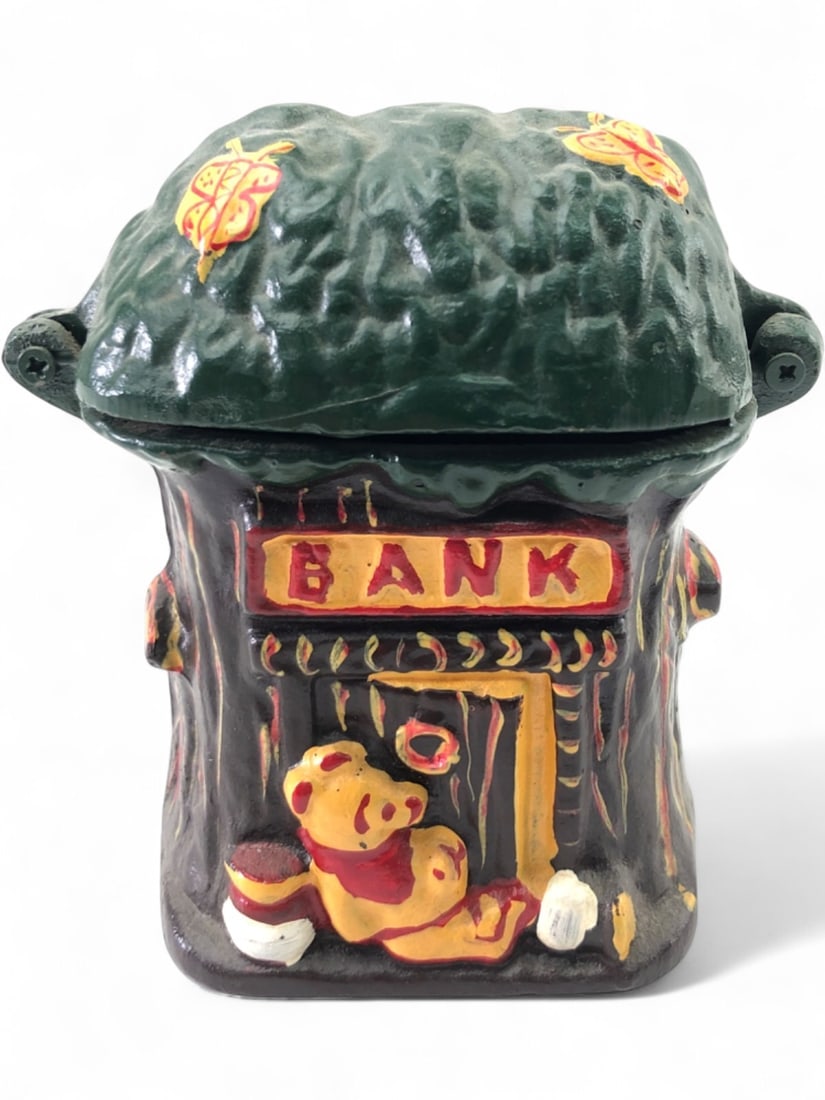Winnie the Pooh Cast Iron Coin Bank, 5" H: Vintage cast iron coin bank featuring Winnie the Pooh with a honey pot, set against a tree stump design with a "BANK" sign. The top is hinged and features a coin slot and butterfly accents. Painted da