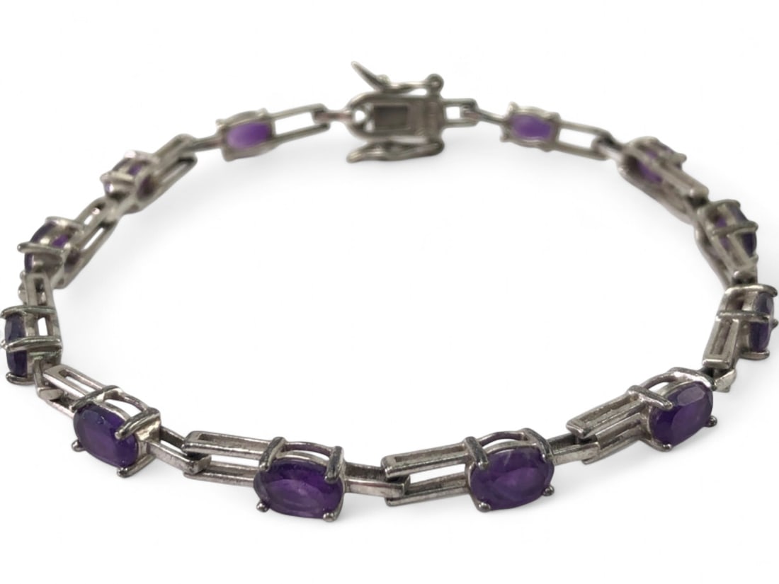 Sterling 925 Amethyst Tennis Bracelet: Sterling 925 silver link bracelet featuring numerous oval-cut amethyst stones in a classic tennis bracelet design. Each stone is set in an individual link connected by rectangular bars. Secured with a