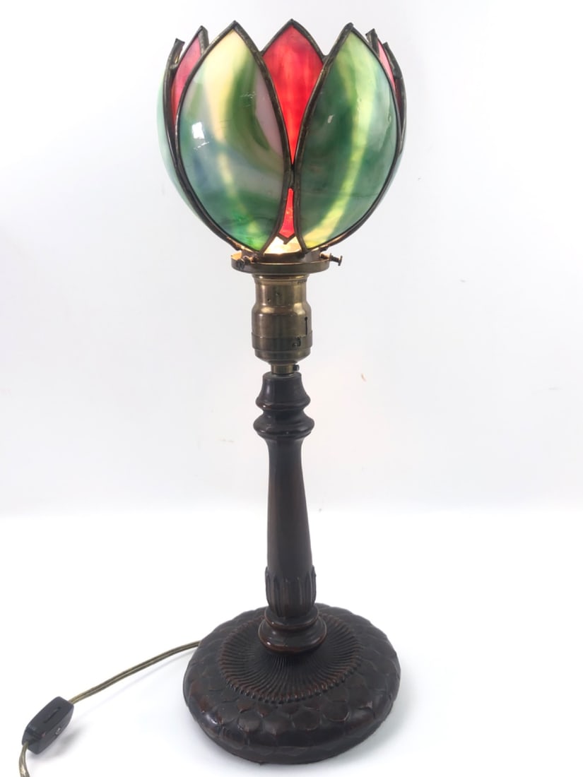 Slag Glass Lotus Table Lamp: Slag glass and metal table lamp in the style of Tiffany Studios. Features a lotus flower-shaped shade with green and pink marbled slag glass panels set in a leaded metal frame. The cast metal base has
