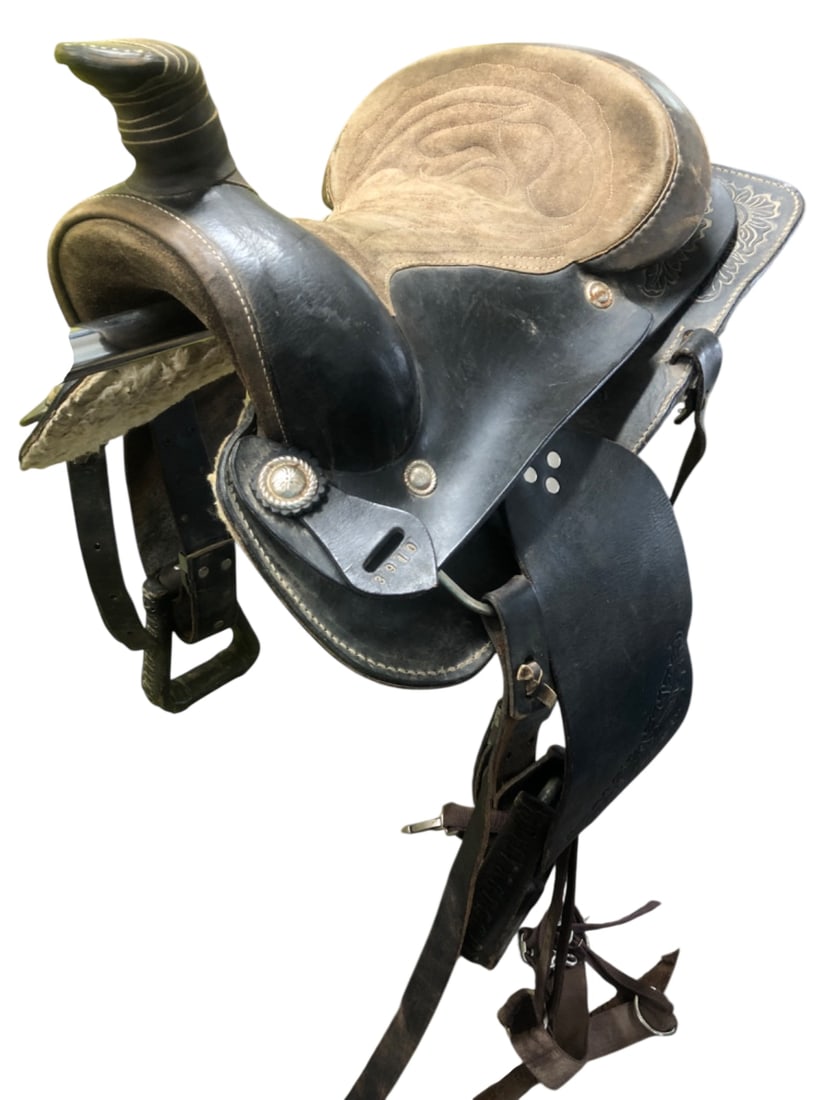 Western Leather Roping Saddle with 15 Inch Seat: Western style leather saddle featuring a 15 inch seat with decorative stitching. The saddle is constructed from black and brown leather with floral stamped accents on the fenders and skirts. Includes 