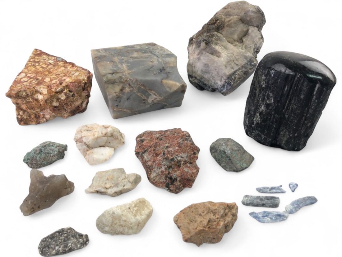 Assorted Mineral and Rock Specimen Collection: A diverse collection of mineral and rock specimens including a large polished black tourmaline, a slab of grey agate or chert, a piece of leopard skin jasper, kyanite blades, rose quartz, granite, and