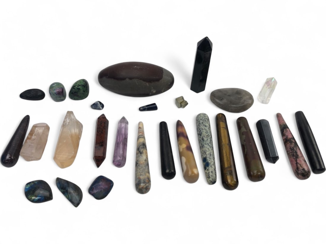 Assorted Polished Gemstone and Crystal Collection: A diverse collection of polished gemstones and crystals in various shapes including wands, points, and tumbled stones. Featured specimens include labradorite cabochons, amethyst point, tiger's eye wan