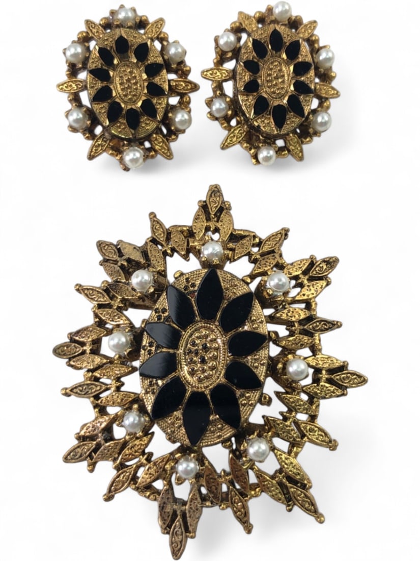 LJMC Gold Tone Brooch and Clip-On Earring Set: Vintage jewelry set by LJMC featuring a 2.25" long brooch and matching clip-on earrings. Pieces are constructed from textured gold-tone metal accented with black enamel petals and faux pearl