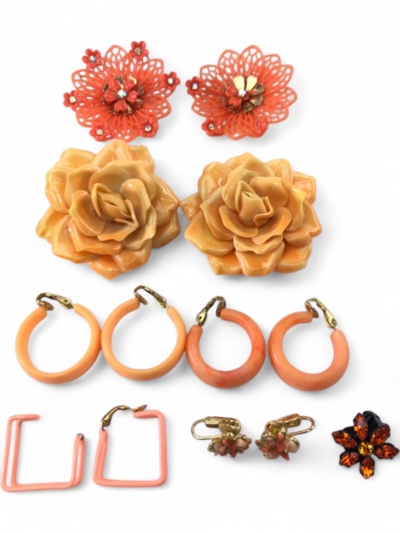 Coro and Assorted Orange Peach Costume Jewelry Lot: A collection of vintage costume jewelry in shades of orange and peach. Includes a pair of large floral clip-on earrings signed Coro with openwork plastic petals and rhinestone centers. Also features a