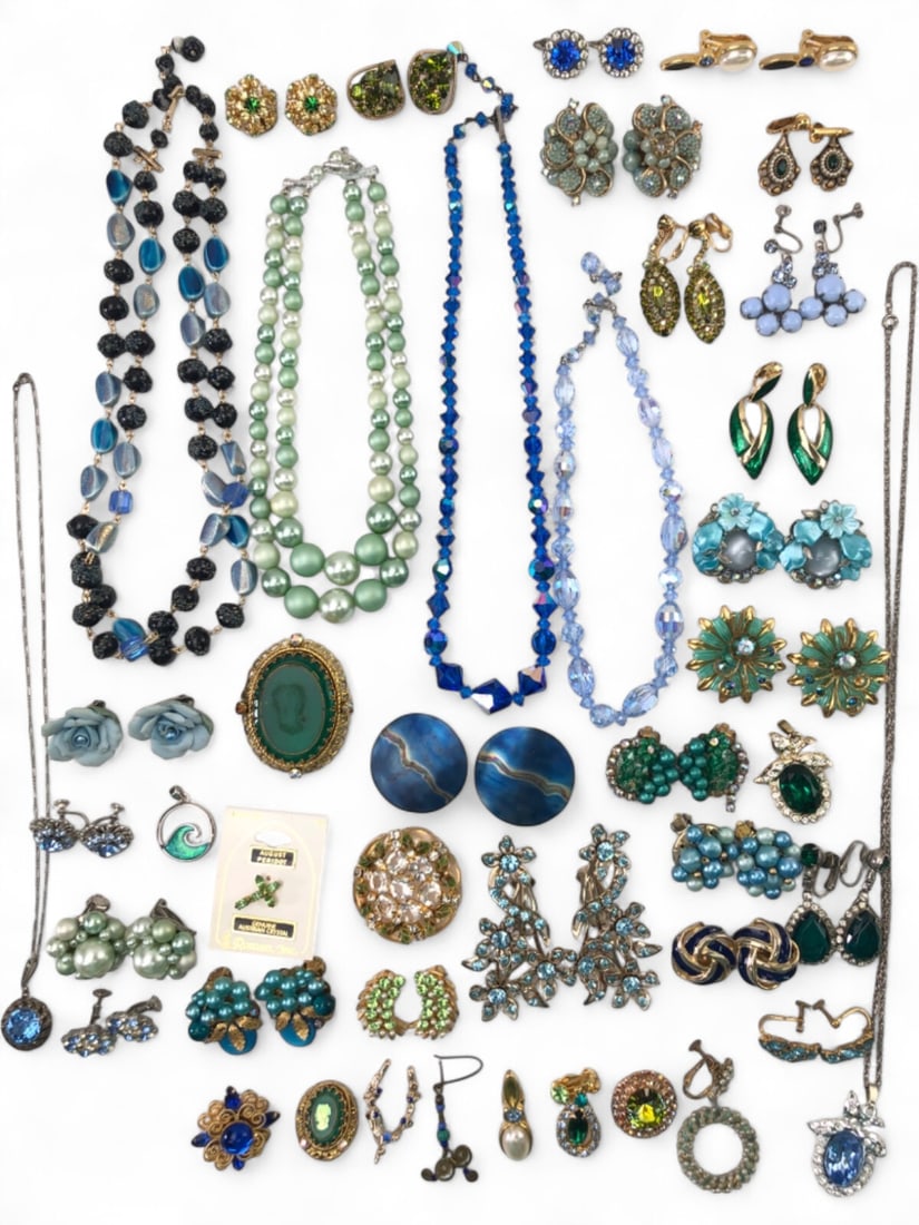 Roman, Inc. and Unsigned Vintage Costume Jewelry Lot: A diverse collection of vintage costume jewelry featuring green and blue tones. Includes a Roman, Inc. August Peridot pin on original card, beaded necklaces, clip-on and screw-back earrings, brooches,