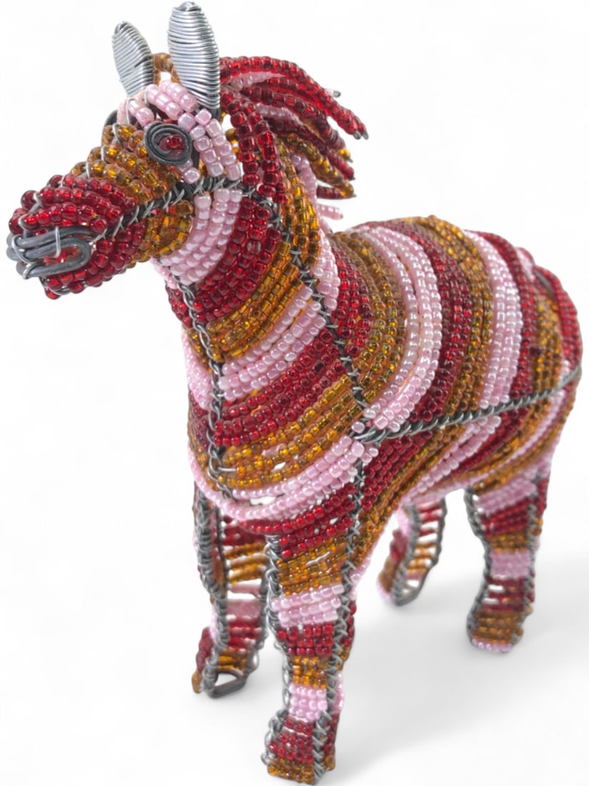 African Bead and Wire Folk Art Zebra Sculpture: Handcrafted African folk art zebra sculpture. Constructed from a galvanized wire frame intricately wrapped with glass seed beads in striped patterns of red, amber, and pink. Features coiled wire ears 