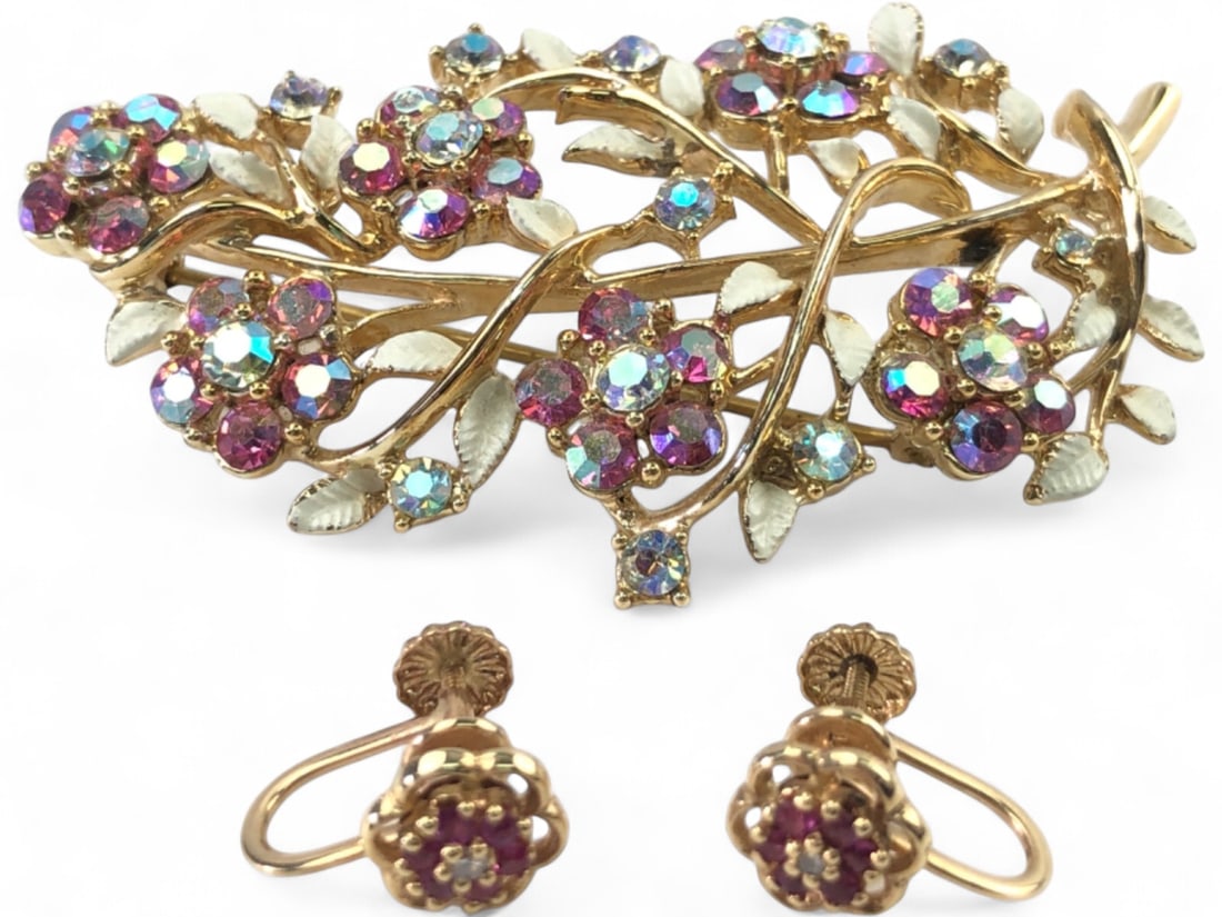 Vintage Floral Brooch and Screw-Back Earrings Set: Vintage costume jewelry set featuring a floral spray brooch with aurora borealis and pink rhinestones, accented with white enamel leaves. Brooch measures 2.5" wide. Accompanied by a pair of 10K gold s