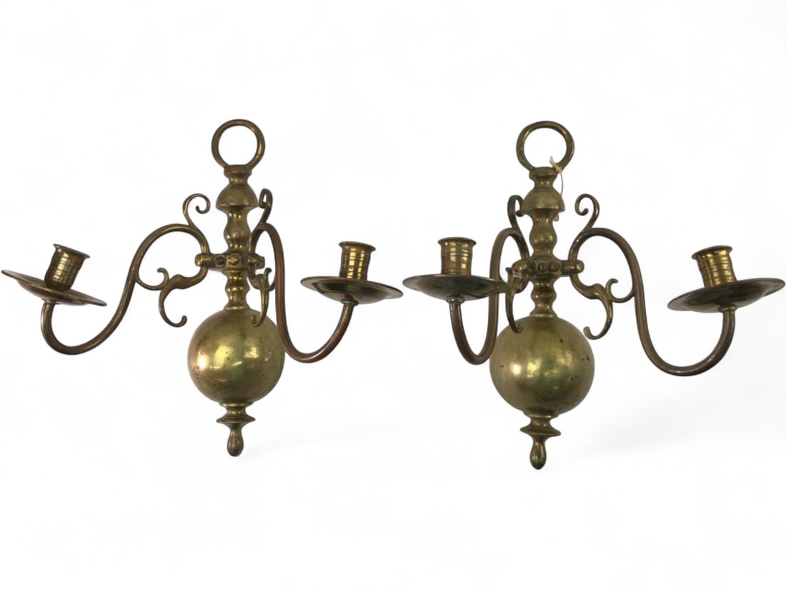 Pr. Dutch Style Brass Double Armed Wall Sconces: Pair of brass double-armed wall candle sconces in the Dutch Baroque style. Each features a central baluster-form backplate with a spherical base and ring finial. The scrolling arms support circular