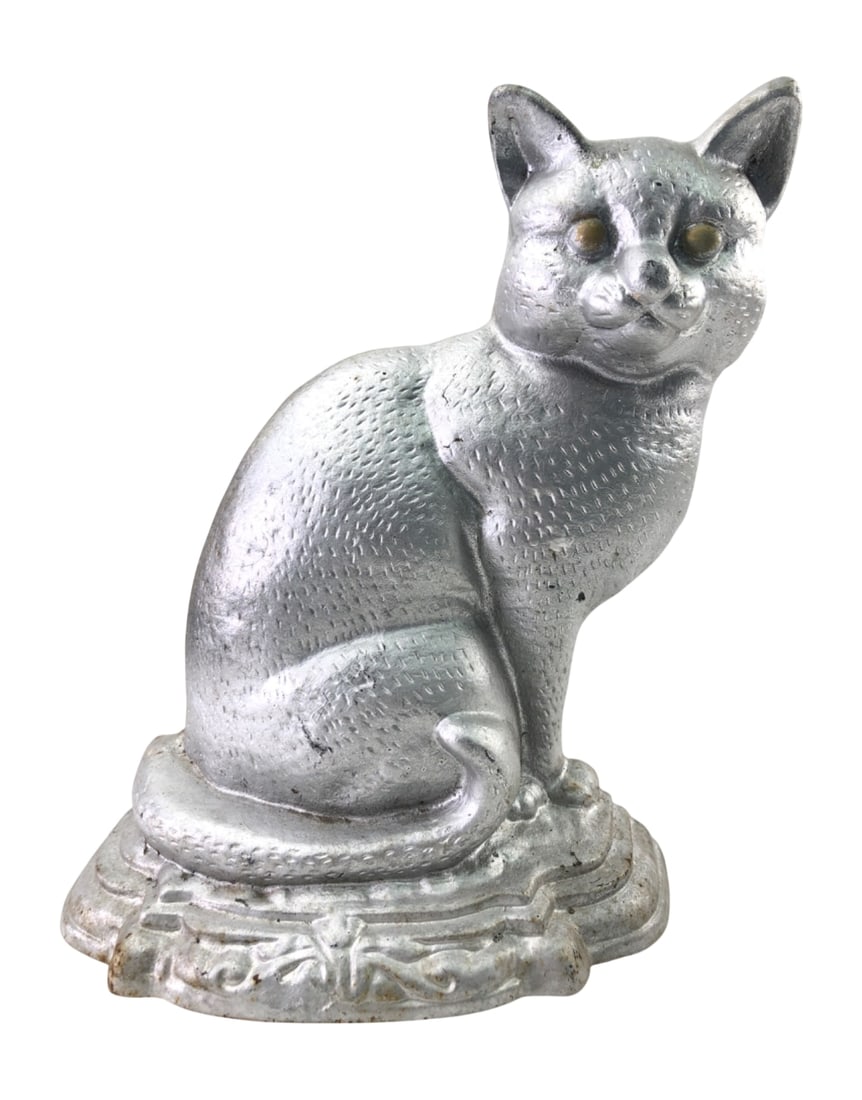 Cast Iron Seated Cat Doorstop: Cast iron seated cat doorstop with a silver-tone painted finish. Features textured fur details, glass or marble inset eyes, and a hollow-back construction. The piece is unmarked. Shows surface wear, p