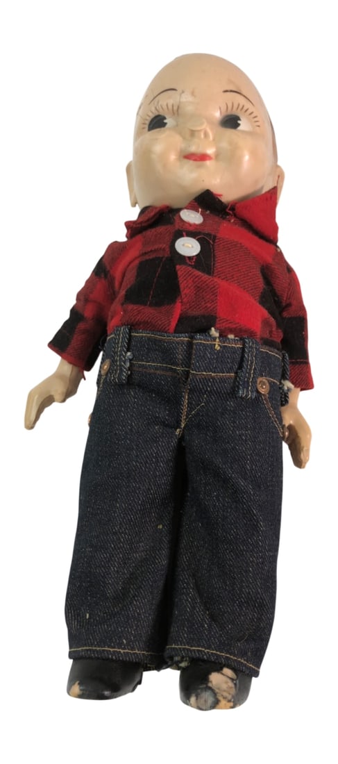Buddy Lee Composition Doll in Plaid and Denim: Vintage Buddy Lee composition doll wearing a red and black buffalo plaid flannel shirt and denim jeans. The jeans feature a yellow fabric 'Union Made Lee' label on the back. The doll has a molded and 