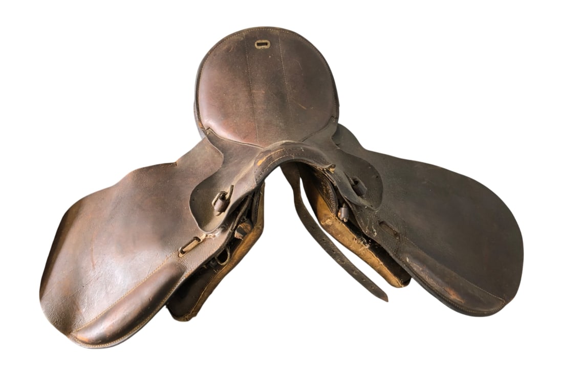 German WWII Wehrmacht M34 Cavalry Saddle: German WWII Wehrmacht M34 cavalry saddle. Constructed of dark brown leather with padded underside. Features metal hardware and a stamped maker's mark 'dde 44' on the leather flap, indicating productio