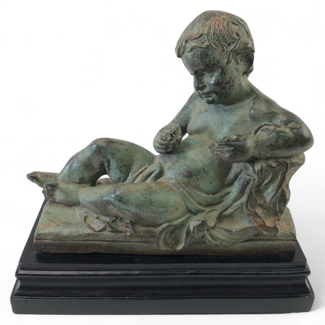 Neoclassical Manner Cast Metal Reclining Cherub Statue: Neoclassical manner cast metal statue of a reclining cherub. Features a verdigris-style patina and is mounted on a black rectangular base. Measures 10" x 5" x 9.5" H. Condition: shows surface wear