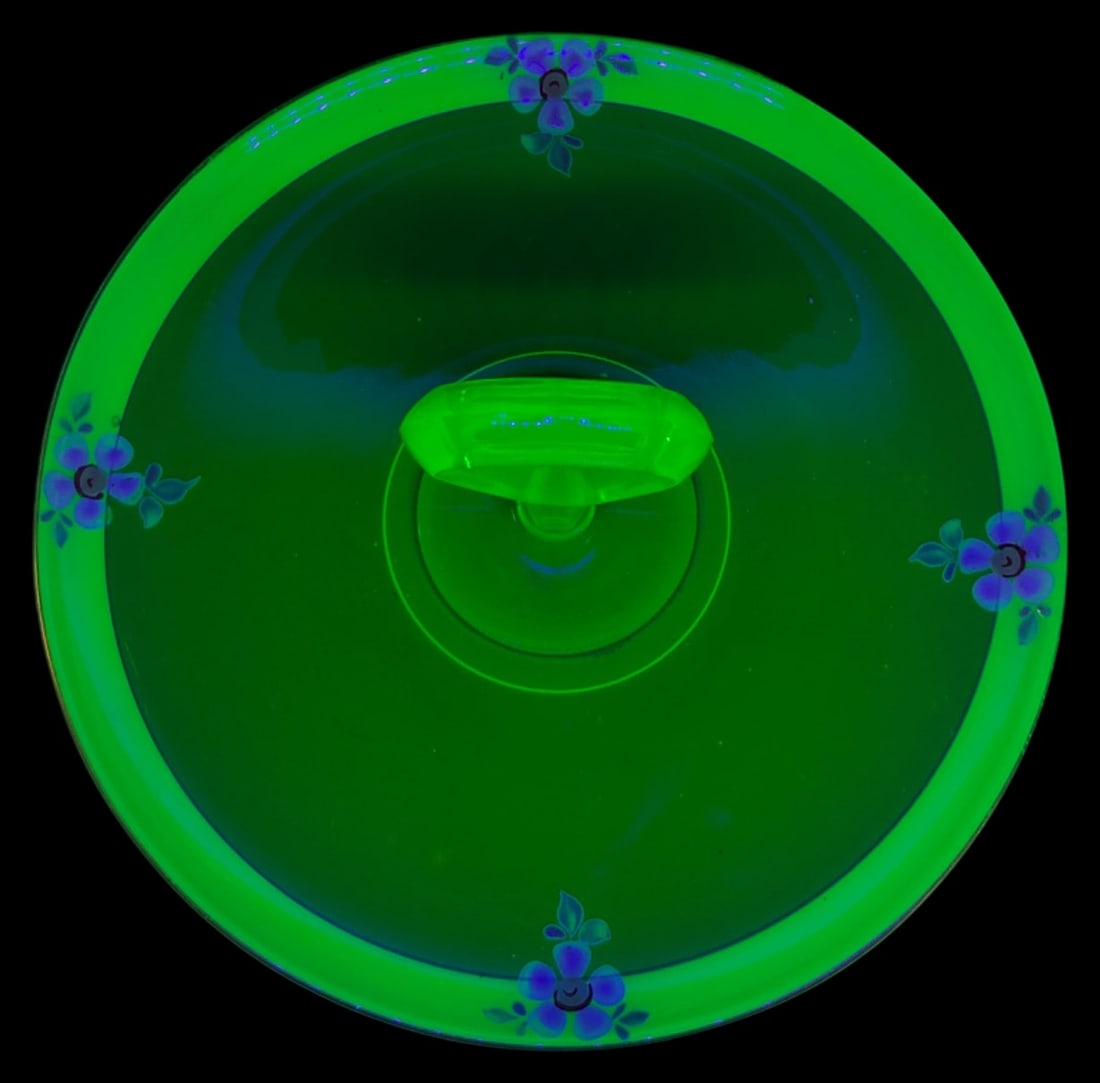 Tiffin Uranium Glass Tidbit Tray with Loop Handle: Circa 1930s uranium glass tidbit tray by Tiffin. The piece features a deep forest green center with a lighter green frosted rim, accented by hand-painted white floral motifs and gold-tone trim. A