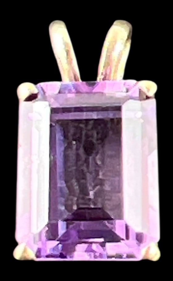 14K Yellow Gold Emerald Cut Amethyst Pendant: A 14 karat yellow gold pendant featuring a central emerald cut amethyst, approximately 9x7 mm. The gemstone is held in a four-prong setting with a split-v bale. Marked 14K on the bale. Total weight