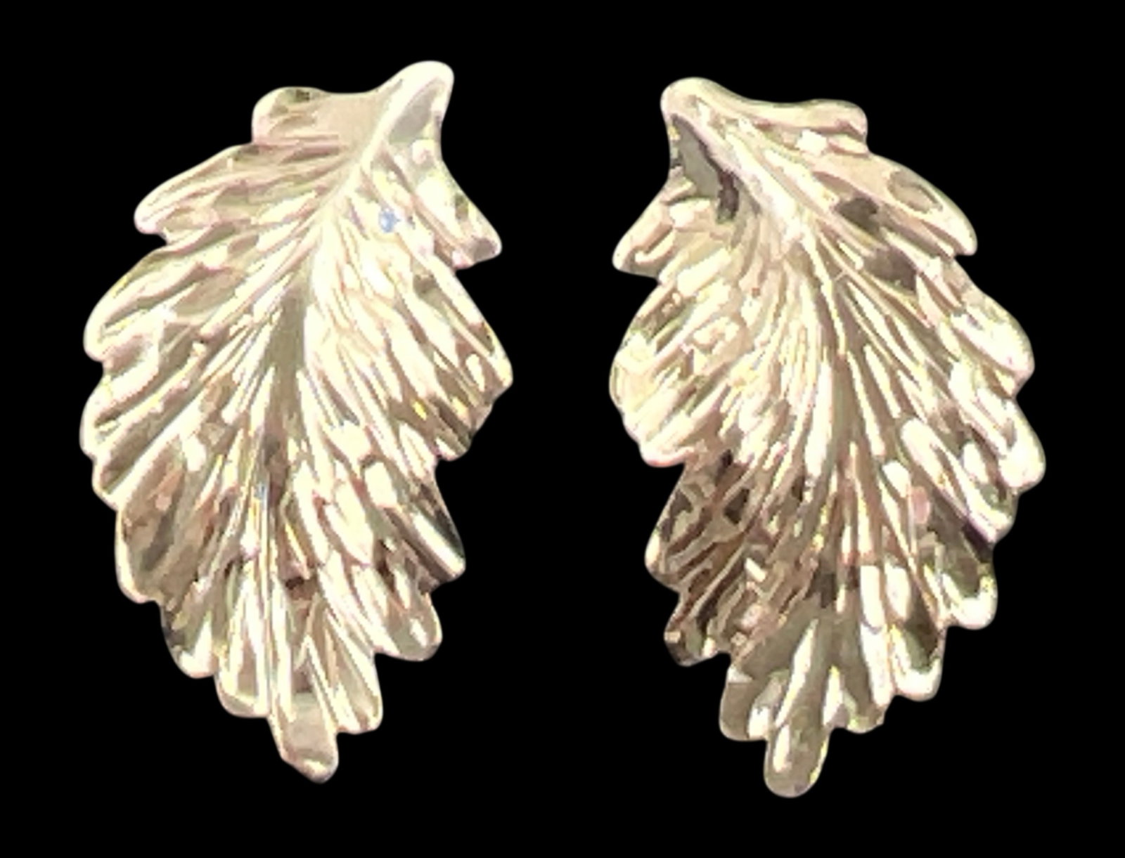 14K Gold Leaf Stud Earrings: Pair of leaf-motif stud earrings crafted in 14 karat yellow gold. The earrings feature a textured, diamond-cut finish to simulate the veins of a leaf. Each earring is secured with a friction post and
