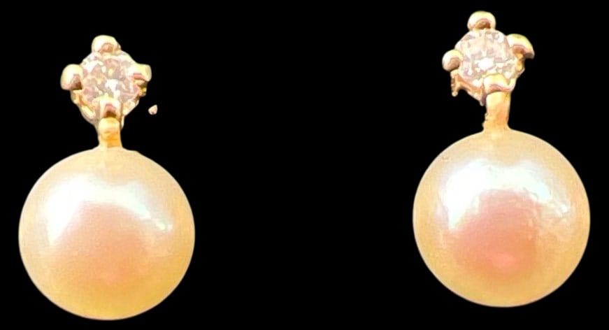 14K Gold Cultured Pearl and Diamond Earrings: Pair of stud earrings crafted in 14 karat yellow gold, each featuring a cultured pearl measuring approx. 4.5 mm. Accented with a small round-cut diamond set in a four-prong mounting. The butterfly