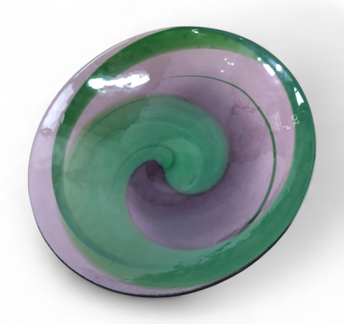 Murano Glass Green and Purple Swirl Centerpiece Bowl: Hand-blown art glass centerpiece bowl featuring a vibrant green and purple spiral swirl pattern. The piece has a textured, hammered-effect exterior and a smooth interior. Retains original red and gold