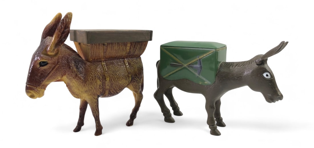 VTG Accoutrements Molded Plastic Donkey Cigarette Dispensers: Pair of vintage molded plastic cigarette dispenser donkeys. Includes one brown donkey with a woven-style pack and one dark brown donkey with a green pack featuring a pickaxe and shovel motif. The gree