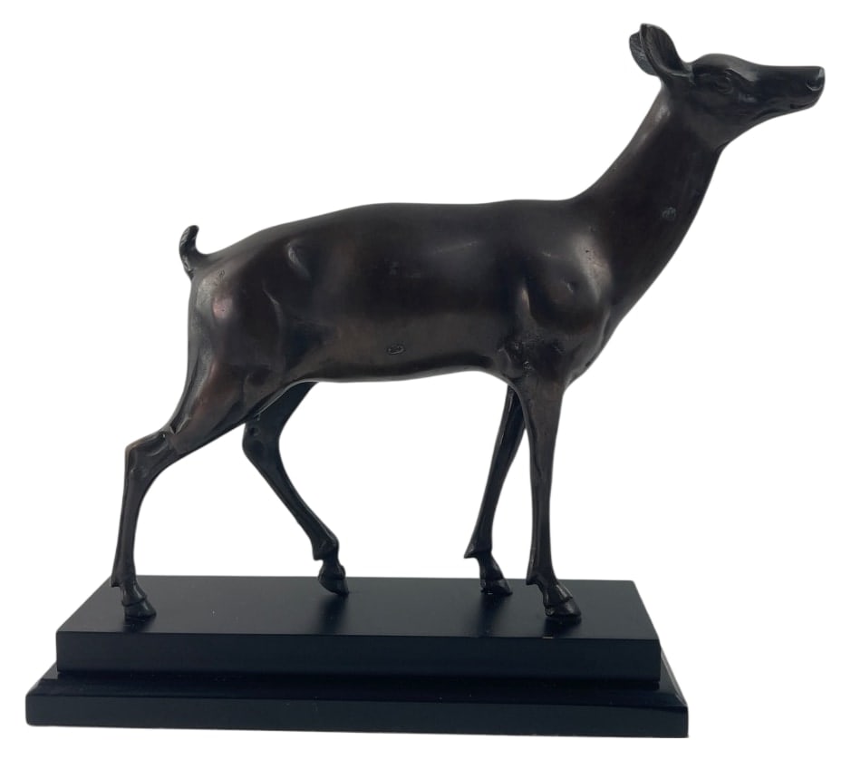 Bronze Doe Sculpture on Plinth Base: A cast bronze or similar material, hollow, sculpture of a standing doe, depicted with its head raised and ears alert. The figure features a dark brown patina and is mounted on a tiered black wooden pl