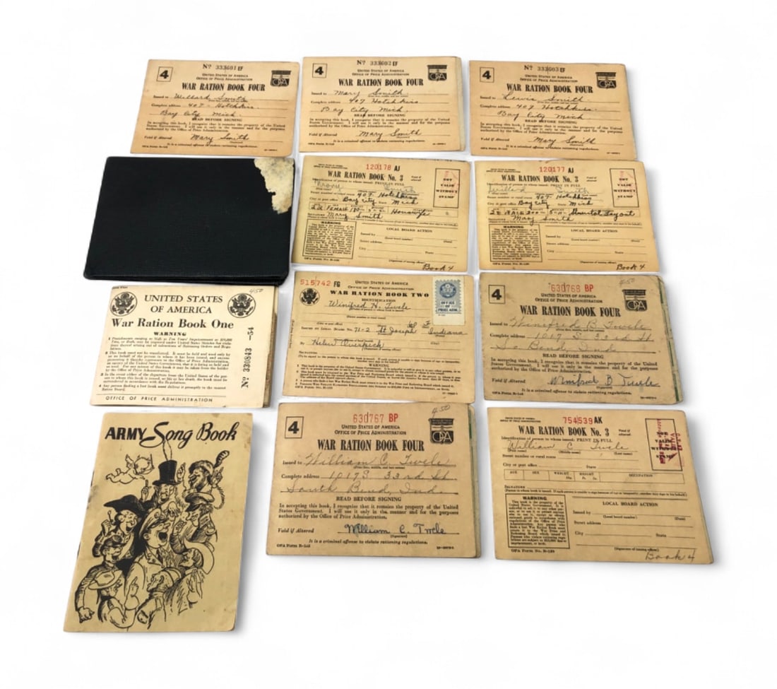 c. 1942-1943 United States War Ration Book Collection and Army Song Book: Collection of WWII-era ephemera including nine United States War Ration Books (Nos. 1, 2, 3, and 4) issued to members of the Smith and Twele families of Michigan and Indiana. Includes a black