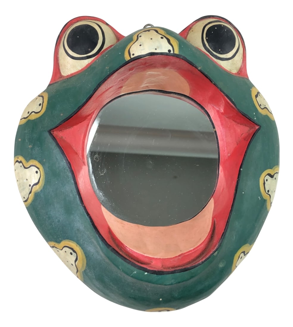 Balinese Folk Art Hand-Painted Frog Wall Mirror: Hand-painted Balinese folk art wall mirror in the form of a frog. This piece is carved from wood and features a vibrant green body with yellow and black spots, red lips, and large protruding eyes. The