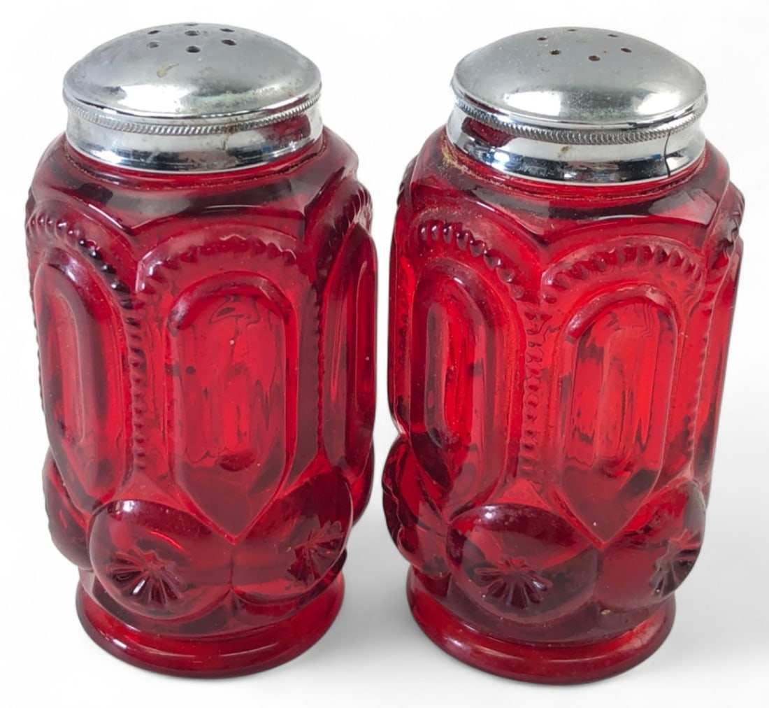 VTG L.E. Smith Moon and Stars Red Glass Shakers: Pair of vintage salt and pepper shakers in the Moon and Stars pattern, attributed to L.E. Smith. Crafted from vibrant red pressed glass with chrome-plated metal lids. Features the classic embossed cel