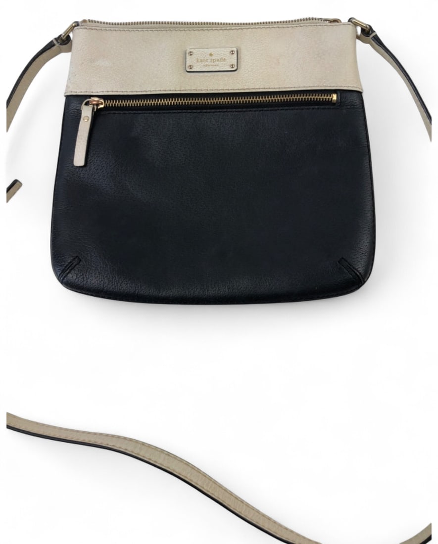 Kate Spade New York Leather Crossbody Bag: Kate Spade New York crossbody bag featuring a two-tone black and cream leather exterior. The bag includes a front zippered pocket, gold-tone hardware, and an adjustable shoulder strap. The interior