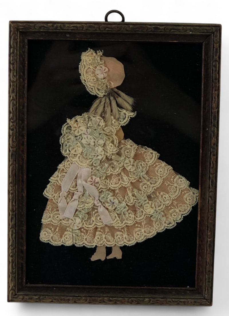 Framed Fabric and Lace Crinoline Lady Artwork: Framed artwork featuring a crinoline lady figure constructed from layered lace, silk ribbon, and fabric. The figure is accented with small fabric rosettes and what appears to be dried botanical