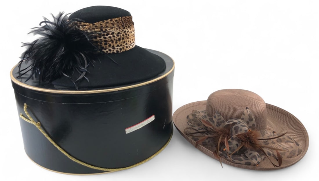 August Accessories Fine Millinery Collection Hats: Pair of ladies' hats from the Fine Millinery Collection by August Accessories. Includes one black wool felt wide-brim hat with leopard print band and black feather plume, and one tan woven