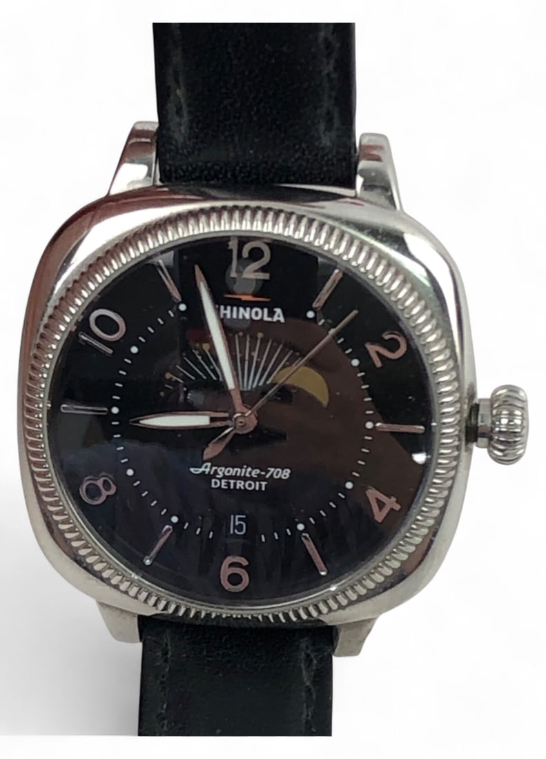 Shinola Argonite-708 Moon Phase Wristwatch: Shinola Argonite-708 moon phase wristwatch featuring a black dial, stainless steel case, and black leather strap with branded buckle. Includes sapphire crystal and 5ATM water resistance. Case back mar