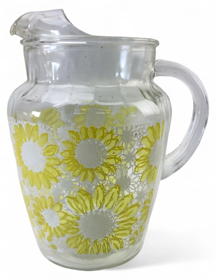 VTG MCM Anchor Hocking Sunflower Glass Pitcher: Vintage Mid-Century Modern glass pitcher by Anchor Hocking featuring a yellow sunflower and lace pattern. Measures 9" H. Features a pour spout and handle. Item is in good condition with no visible chi