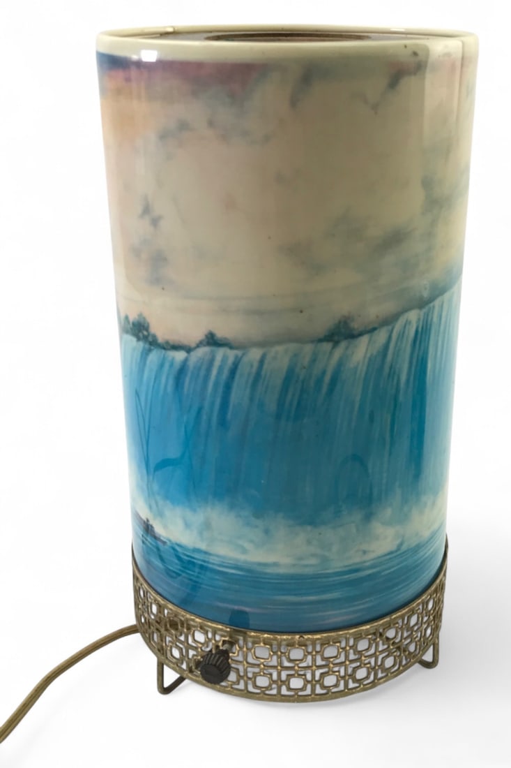 L.A. Goodman Mfg Co Niagara Falls Cylinder Lamp: Mid-century modern Niagara Falls cylinder lamp by L.A. Goodman Mfg Co, dated 1957. Features a scenic glass shade over an inner patterned glass cylinder and a brass-tone geometric fretwork base.