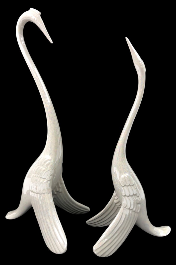 Pair Iridescent Ceramic Swan Figurines 12-14"H: Pair of stylized ceramic swan figurines featuring an opalescent white iridescent glaze and elongated necks. Faint impressed mark near the base is obscured by glaze and illegible. Good condition with