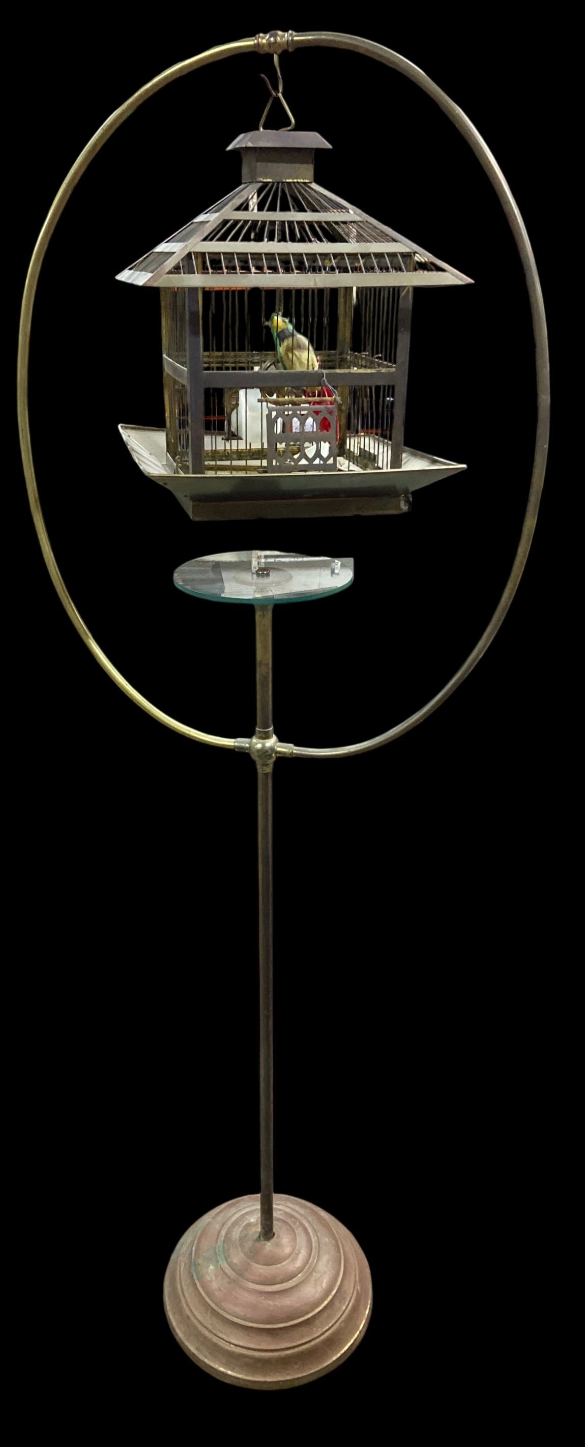 Hendryx Brass Pagoda Birdcage on Hoop Stand: Vintage Hendryx brass pagoda-style birdcage suspended from a circular hoop stand. Features a stepped circular base, wire cage with heart motif door, and interior swing. Shows heavy patina, verdigris