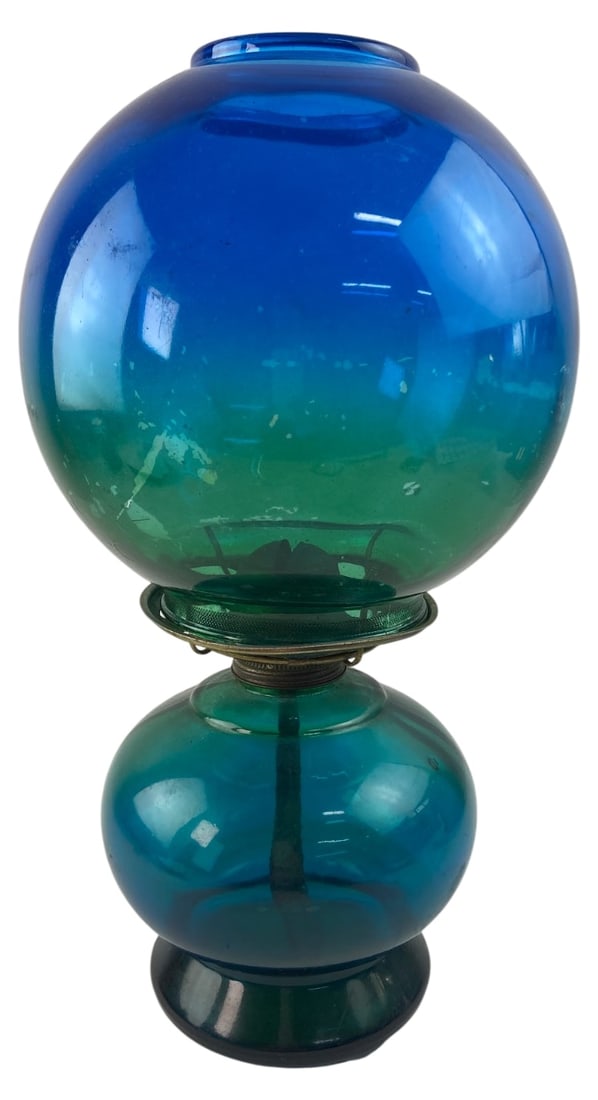 MCM Risdon Blue & Green Flashed Kerosene Lamp: Two-piece glass kerosene lamp featuring a striking blue to green gradient ombre design. Includes the glass reservoir base, matching globe shade, and metal burner with wick. Unmarked. Shows surface