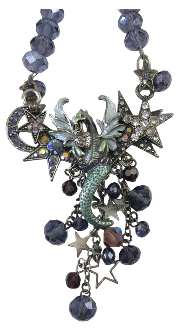 Kirk's Folly Winged Dragon Beaded Necklace: Kirk's Folly fantasy necklace featuring an enameled winged dragon pendant flanked by a crescent moon and stars with rhinestone accents. Suspended from a faceted purple beaded chain with matching