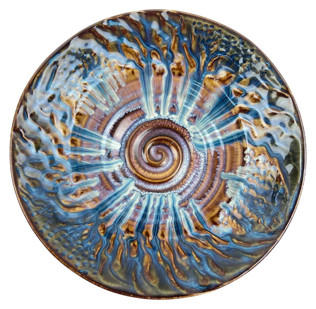 Bill Campbell Porcelain Centerpiece Bowl: Hand thrown porcelain centerpiece bowl by Bill Campbell. Features his signature flambeaux crystalline drip glaze in vibrant blues, golds, and browns radiating from a central spiral design. Incised mak
