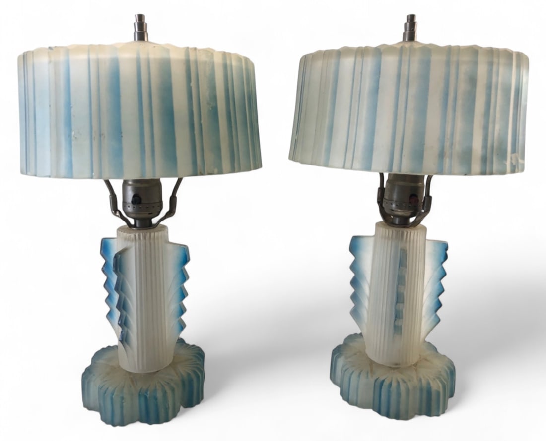 Pair Art Deco Blue Frosted Glass Boudoir Lamps: Pair of Art Deco boudoir lamps featuring a distinct blue and white frosted glass design with a geometric, winged column base and matching ribbed shades. Unmarked. Measures 14"H. Condition: shows some 