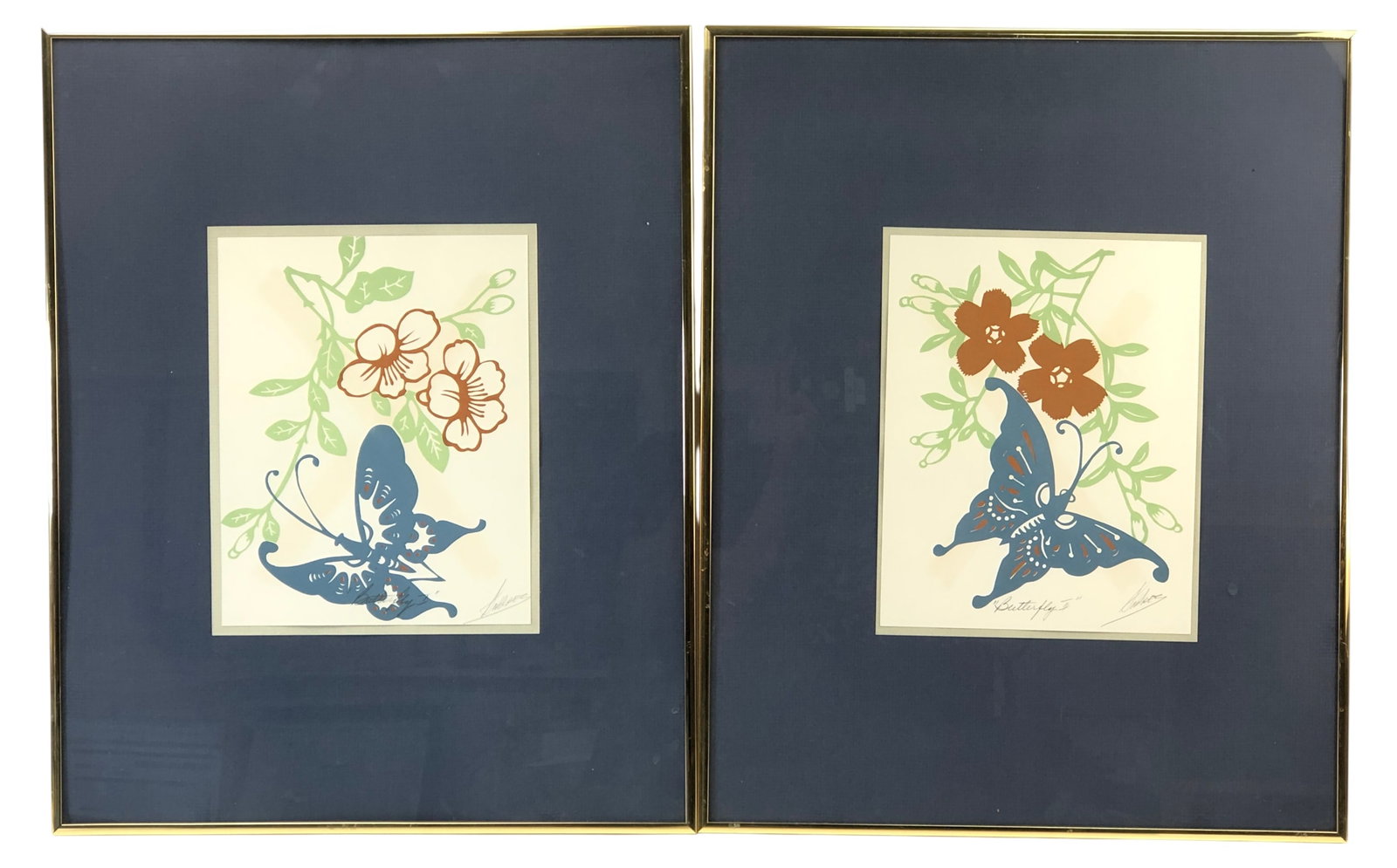 Vanguard Studios Signed Butterfly I & II Prints: Pair of framed prints titled "Butterfly I" and "Butterfly II". Indistinctly pencil signed by the artist. Features blue butterflies with orange and green floral motifs. Housed in gold-tone metal
