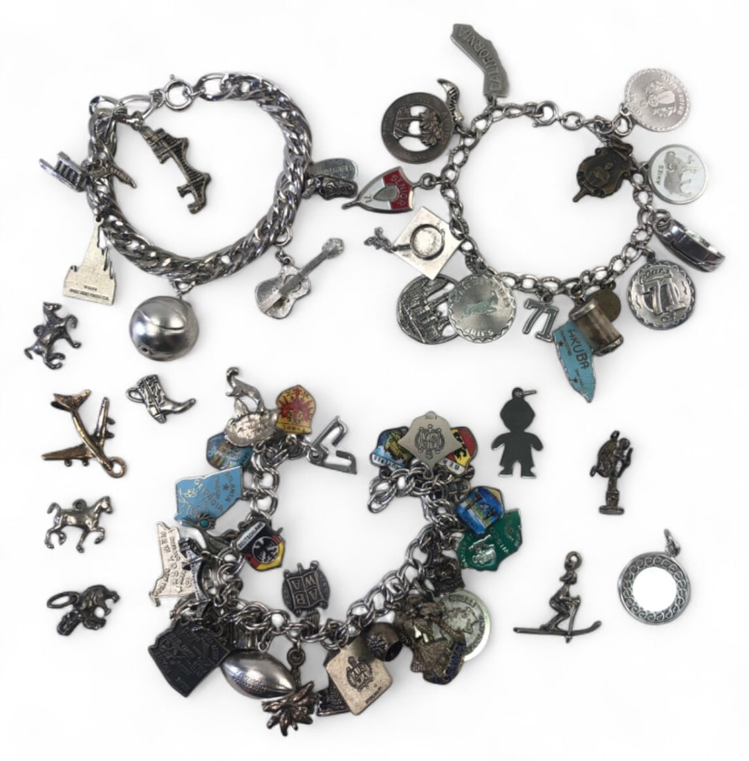 Mixed Sterling Silver Charm Bracelet Lot: Lot includes three chunky link charm bracelets and assorted loose charms. Features travel, hobby, and milestone themes including state maps, graduation cap, zodiac, and sports motifs. Most pieces are