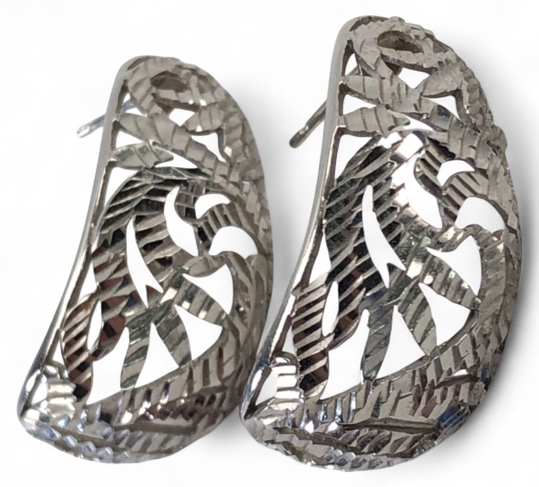 14K White Gold Filigree Half Hoop Earrings: Pair of 14K white gold half hoop earrings featuring a cut-out filigree leaf design with diamond-cut textured detailing. Pierced post backs. Marked "14K" and acid test confirmed. Total weight is 5.08 g