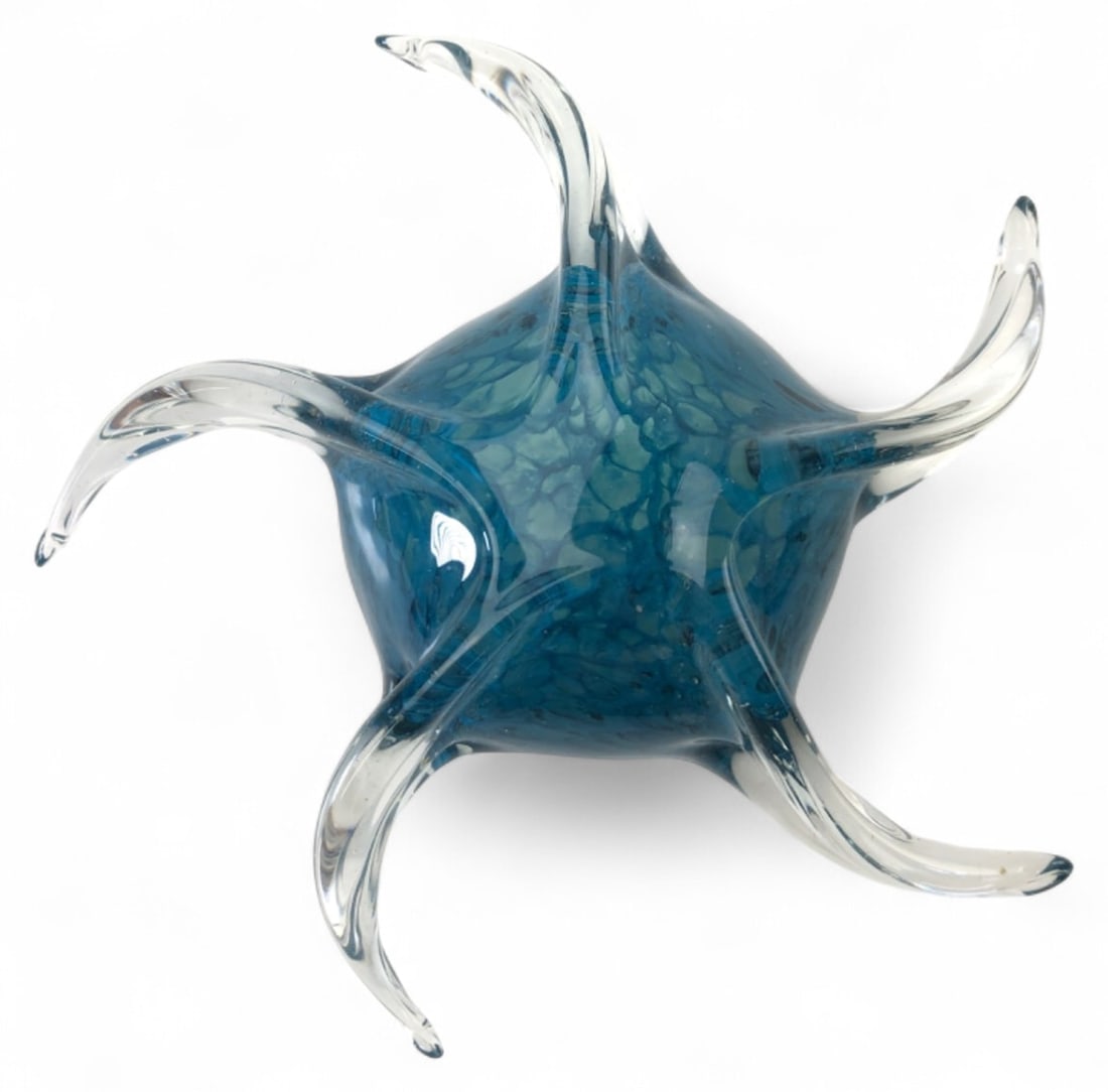 Blue Encased Art Glass Starfish Sculpture: Blue encased art glass sculpture in a five-point starfish design. Features a mottled blue interior cased in clear glass with curved, tapered arms. Unmarked; features a polished pontil base. Measures