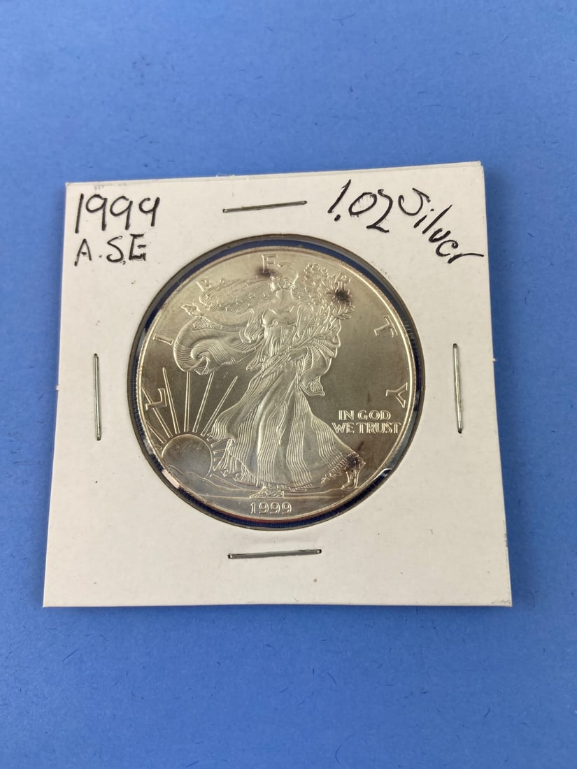 US Mint 1999 American Silver Eagle 1 oz Coin: 1999 American Silver Eagle one dollar coin, struck by the United States Mint. Contains 1 oz of .999 fine silver. Features the iconic Walking Liberty obverse and heraldic eagle reverse. Housed in a car