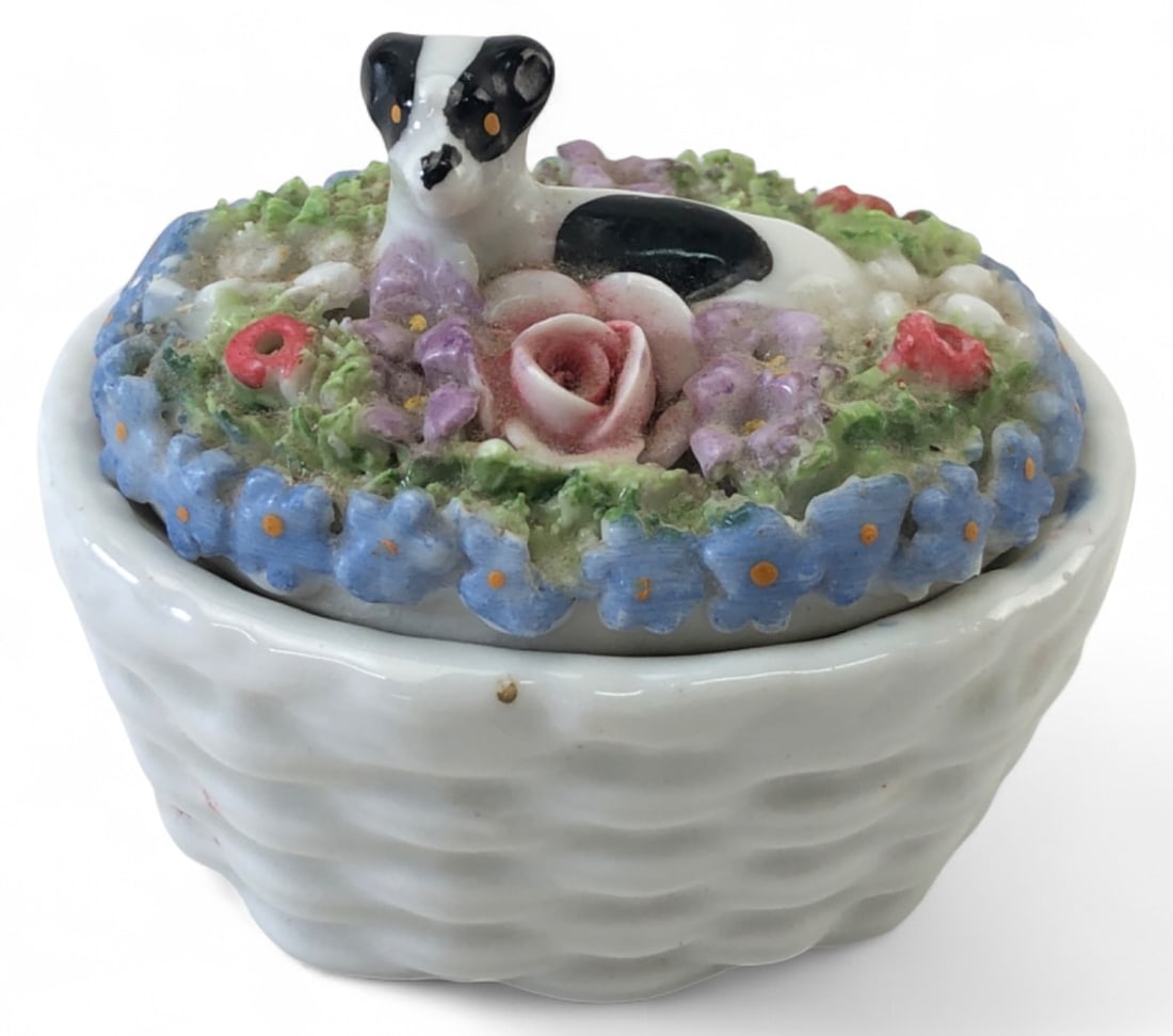 Antique German Elfinware Salt Cellar: Antique German Elfinware covered salt cellar. Features a white basketweave porcelain base and a lid adorned with intricate applied miniature flowers and a resting black and white dog figure. Stamped