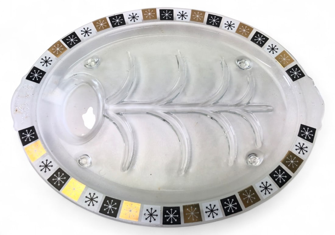 MCM Inland Glass Starburst Carving Platter: Mid-Century Modern clear glass carving platter by Inland Glass. Features a well and tree pattern designed to channel juices into a collection pool, resting on small glass feet. The rim is decorated