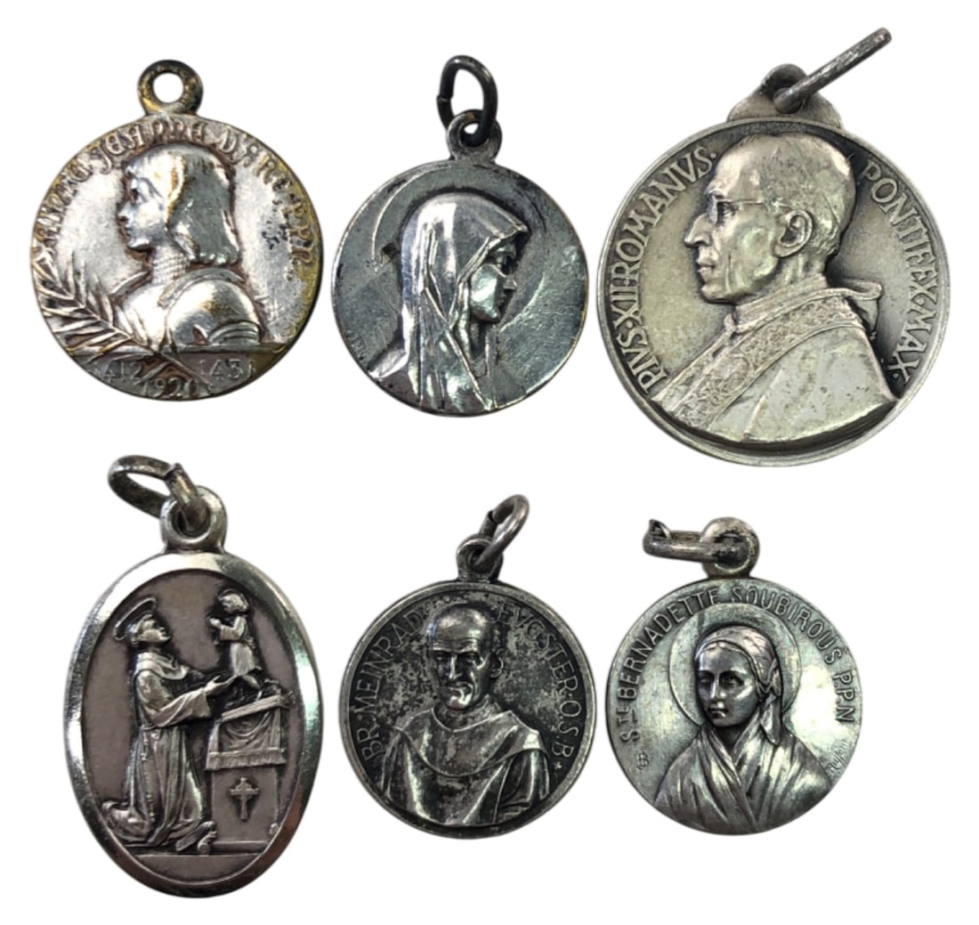 6 Assorted Catholic Religious Medals: Group of 6 silver-tone Catholic religious medals. Features Pope Pius XII, St. Bernadette (Lourdes), Joan of Arc, St. Anthony (St. Peter's Church Chicago), Br. Meinrad Eugster, and a Marian medal.
