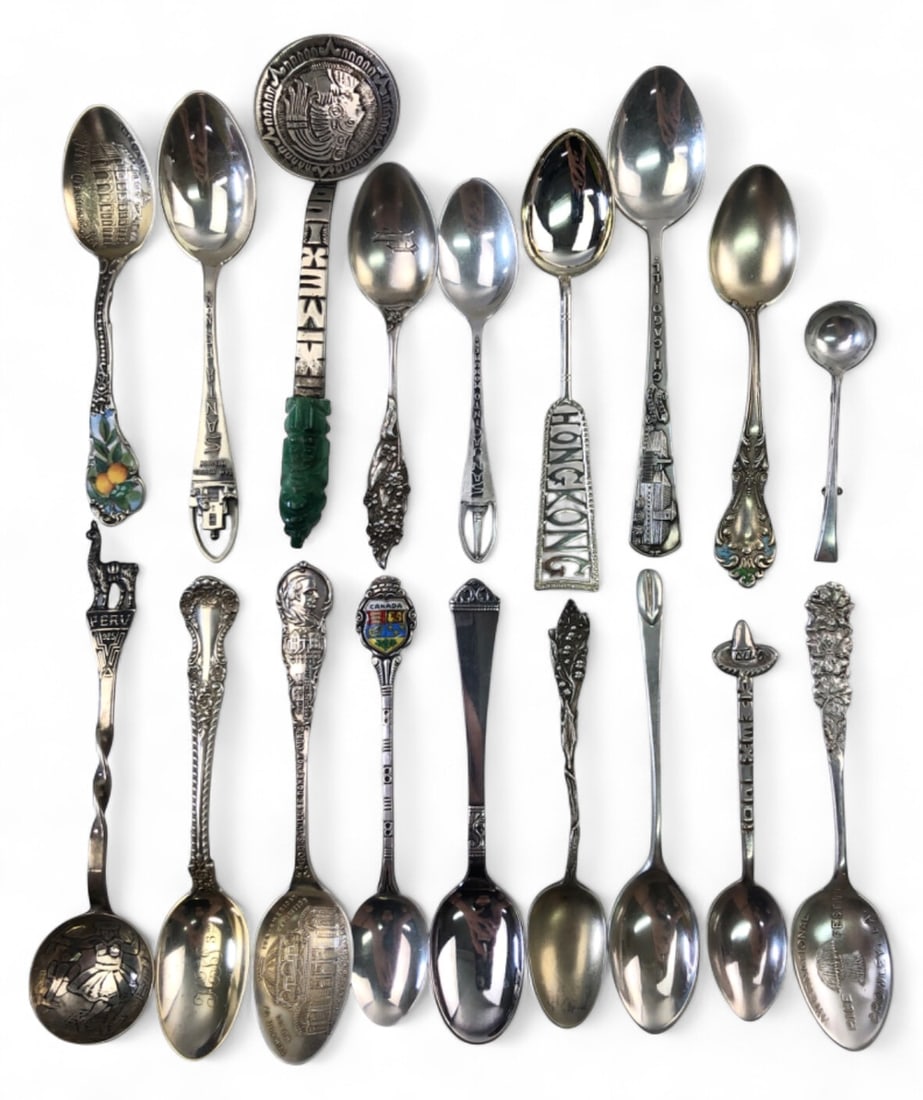 Lot of 18 Sterling Silver Souvenir Spoons: Lot of 18 sterling silver and 925 souvenir spoons from various locations including Peru, New Orleans, Hong Kong, Mexico, and Canada. Features include enamel accents and a carved green stone handle. Ma