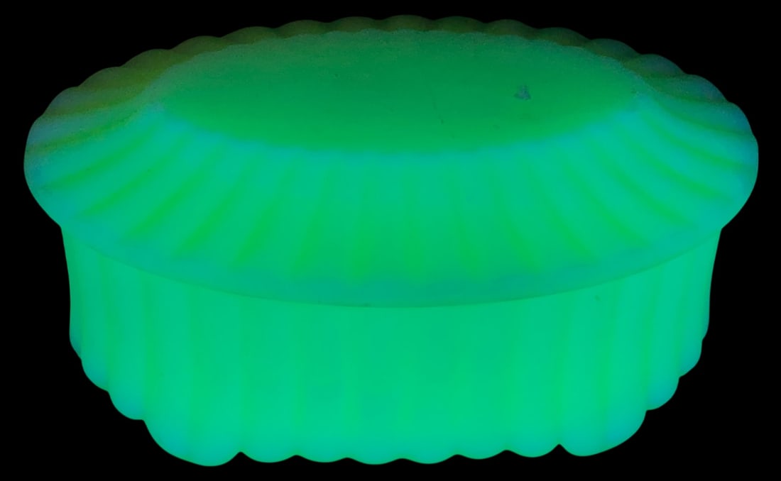 VTG Fenton Satin Custard Glass Trinket Box: Vintage Fenton satin custard glass oval trinket box with lid. Features a ribbed edge design and glows bright green under UV light, indicating uranium content. Marked Fenton on the bottom. Measures 4.5