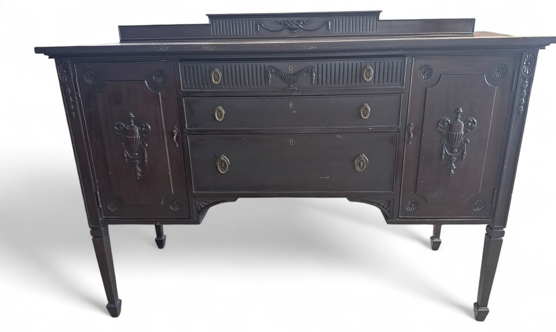 Rockford Chair & Furniture Co. Sideboard: Rockford Chair & Furniture Co. sideboard featuring a dark wood finish, three central drawers, two side cabinets with interior shelves, and decorative urn motifs. Tapered legs with spade feet.